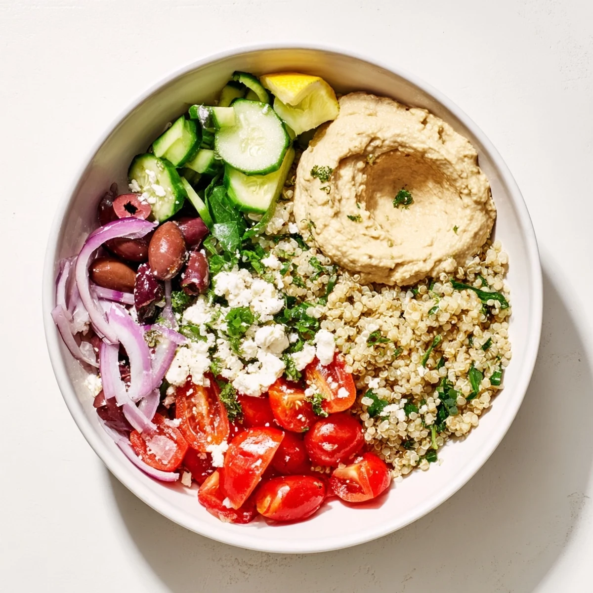 Enjoy a healthy Mediterranean Quinoa Bowl with hummus: a vegetarian delight bursting with fresh flavors.