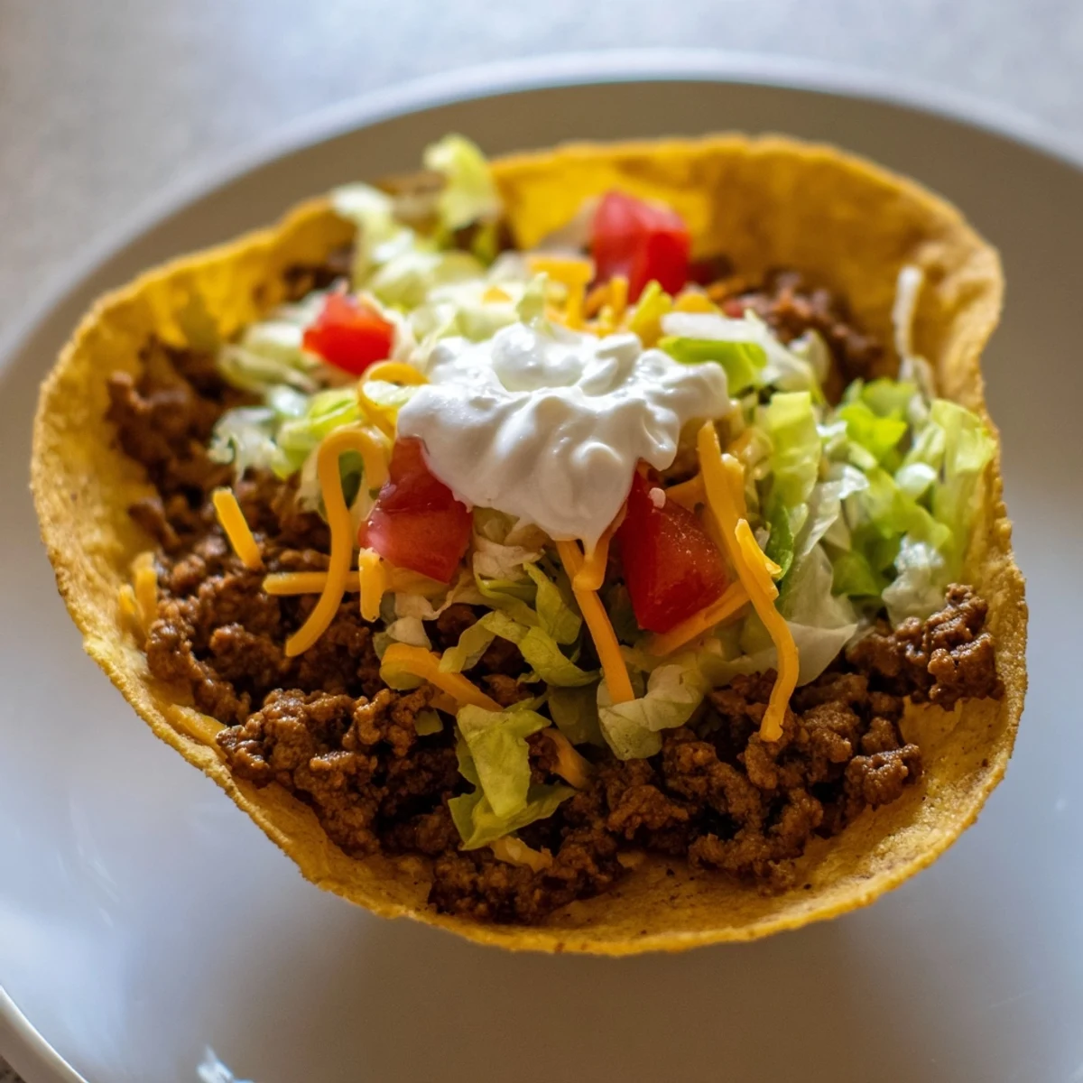 Juicy Beef Tacos with Sour Cream served on a plate with lime wedges for squeezing.